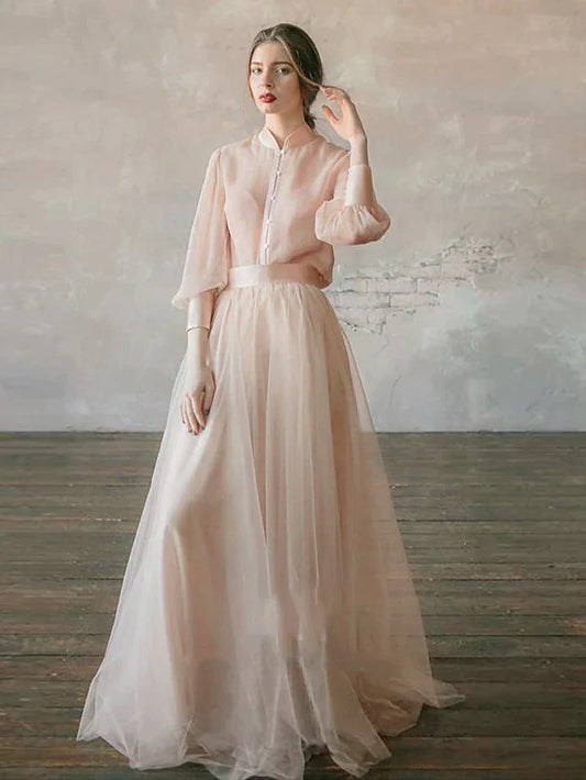 Model in elegant two-piece empire minimalist gown with stand collar and long sleeves.