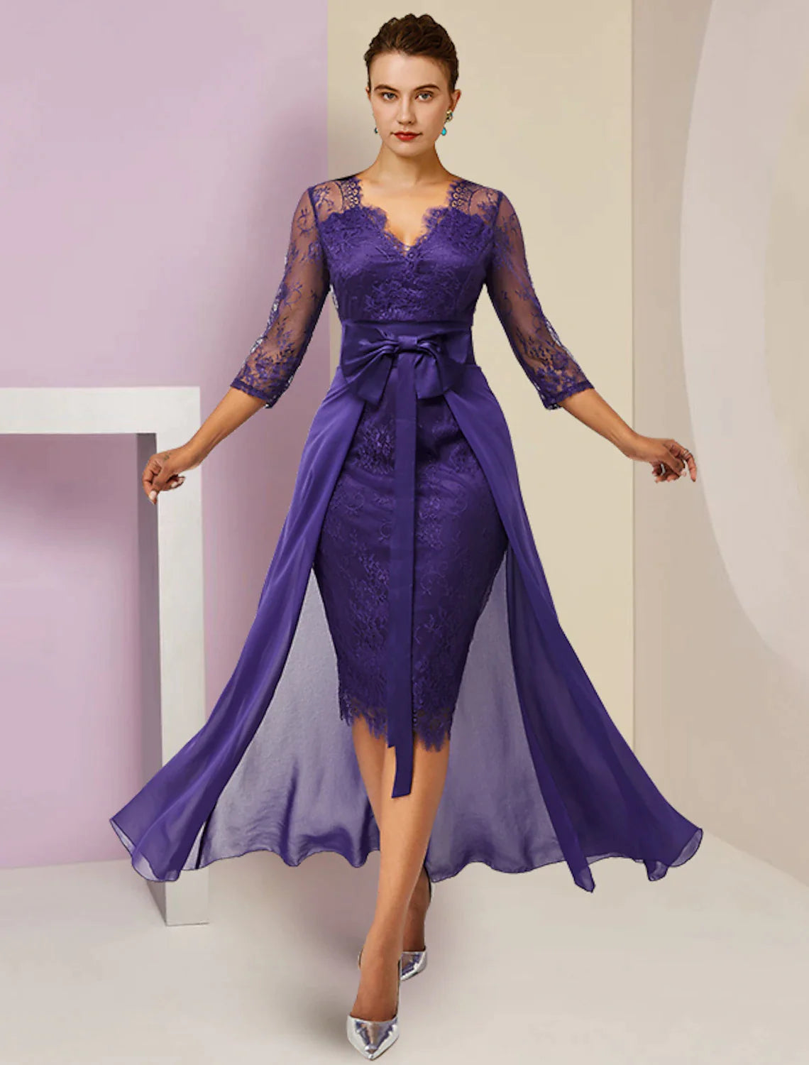 Woman wearing an elegant two-piece sheath mother of the bride dress with a bow detail.
