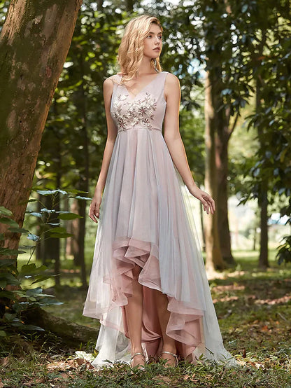 Model wearing an elegant V-neck asymmetrical tulle bridesmaid dress with intricate appliques and a flowing skirt.