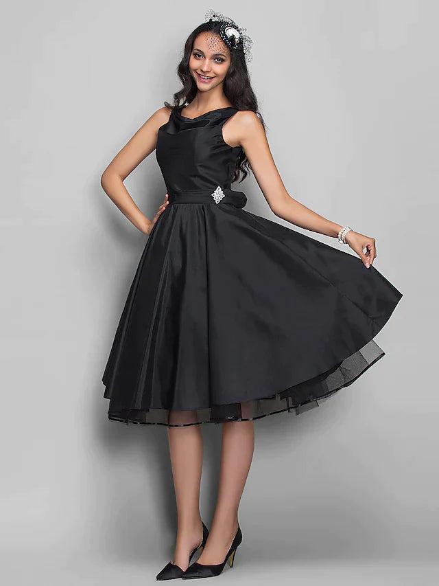 Close-up of the taffeta fabric and crystal embellishments on a knee-length dress.