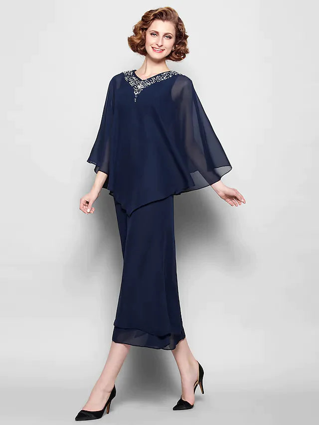 A woman wearing an elegant V-neck chiffon tea length dress with 3/4 sleeves and crystal beading.