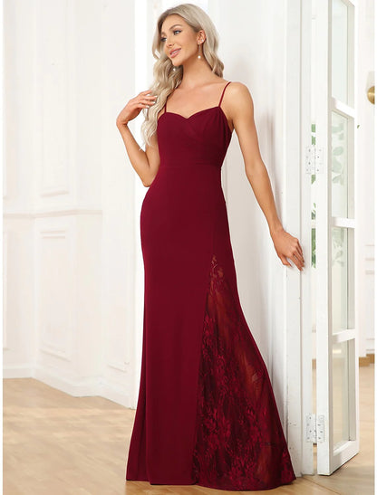 Woman in an elegant V-neck mermaid trumpet gown with cut-out and slit.