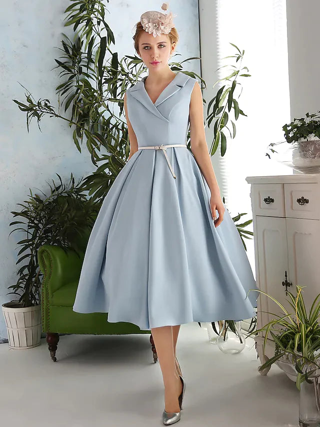 Woman showcasing the front of a tea-length prom dress with a V-neckline.