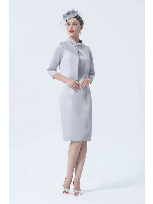 Plus size woman wearing an elegant high neck satin mother of the bride dress with 3/4 sleeves and crystal appliques, front.
