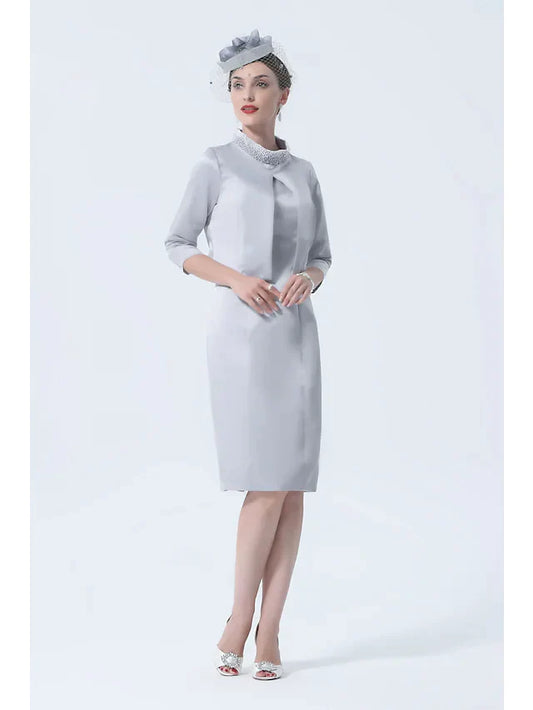 Plus size woman wearing an elegant high neck satin mother of the bride dress with 3/4 sleeves and crystal appliques, front.