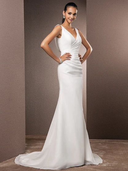 Model wearing an elegant V-neck chiffon wedding dress with a court train.