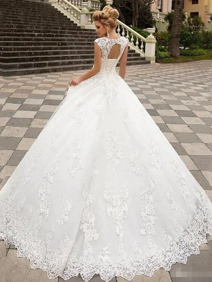 White lace V-neck cap sleeve ball gown wedding dress, back view with open back detail.