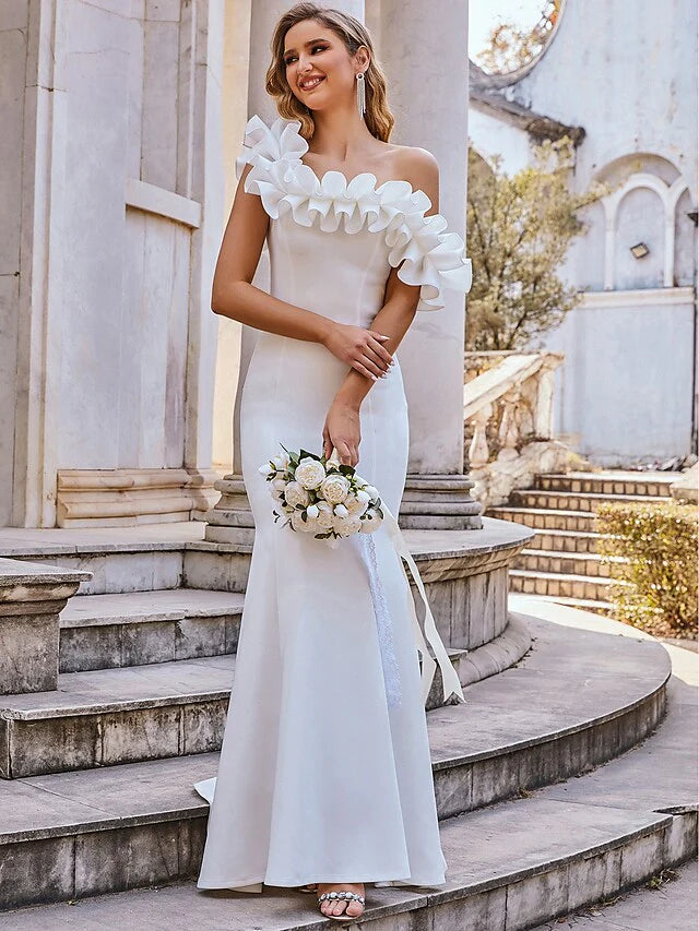 White off-shoulder mermaid wedding dress with ruffles, side view showing the flared hem.