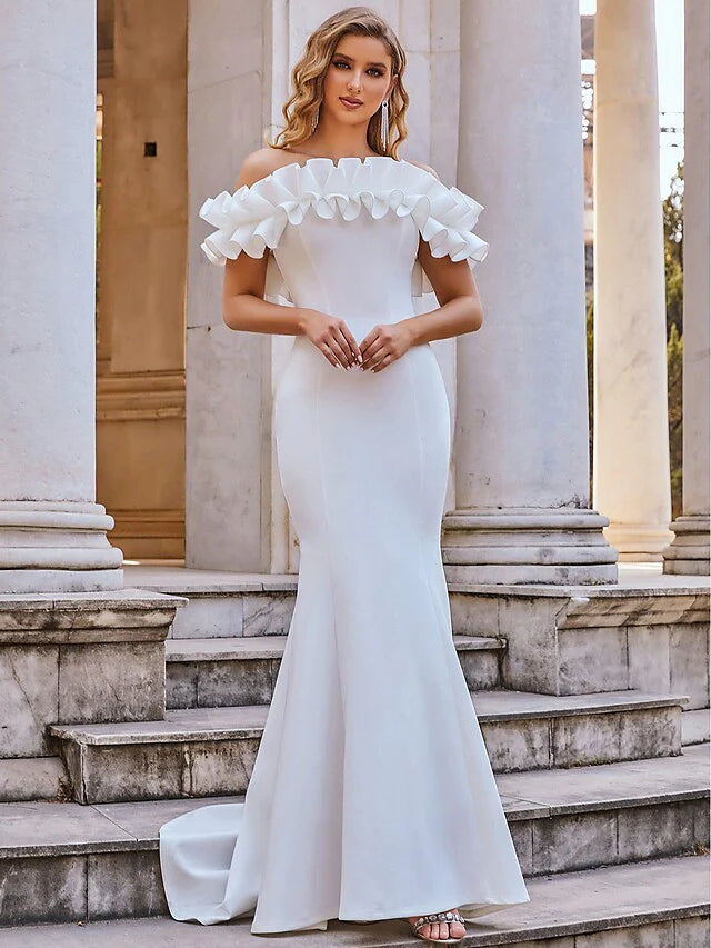 Back view of a white off-shoulder ruffled mermaid wedding dress.