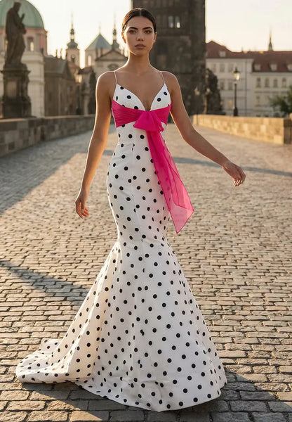 Elegant white polka dot mermaid prom dress with spaghetti straps and a pink bow.