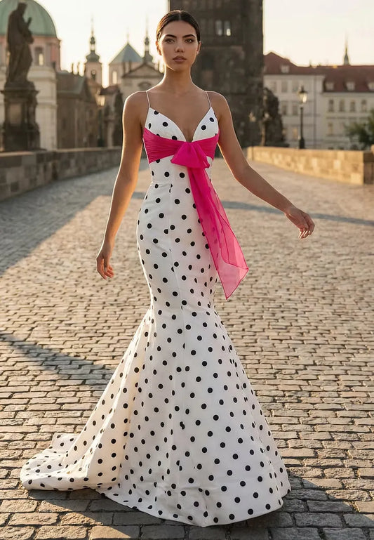 Elegant white polka dot mermaid prom dress with spaghetti straps and a pink bow.