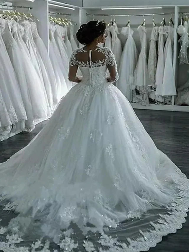 Side view of backless A-line wedding dress with lace long sleeves and court train.