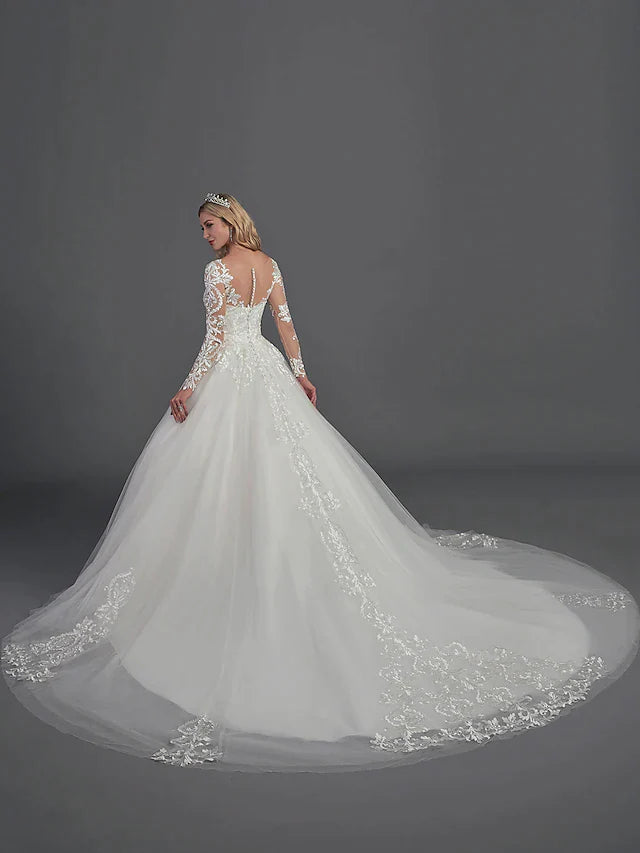 Side view of a bride in a ball gown wedding dress, showcasing the full skirt and chapel train.