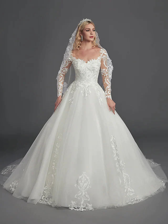 Bride from behind, showing the elegant chapel train and detailed illusion back of the ball gown.