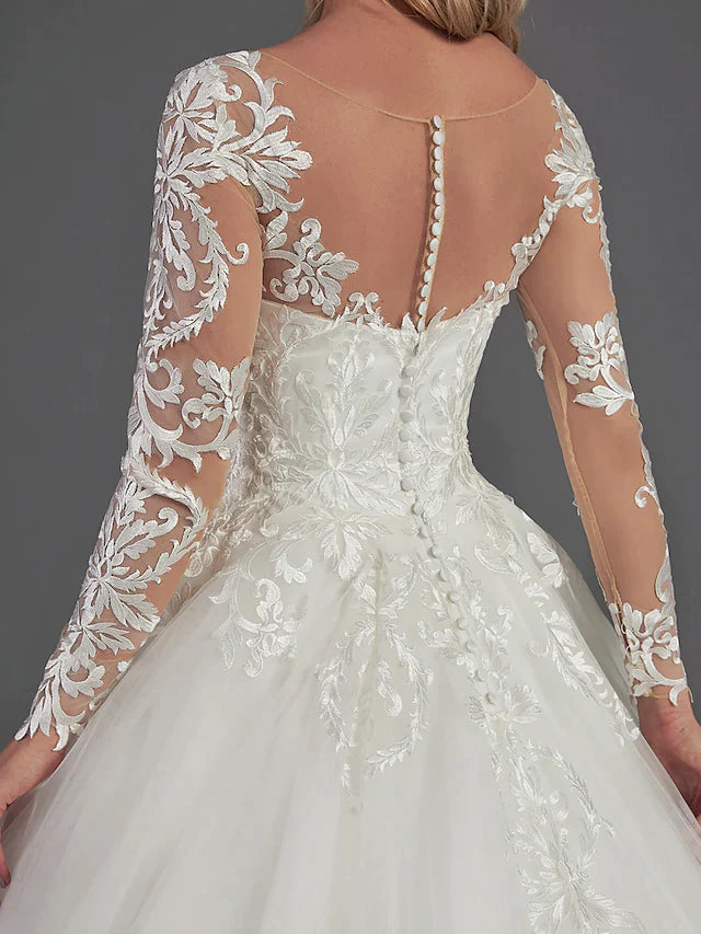 Detailed view of the delicate lace appliques on the long sleeves and bodice of the wedding dress.