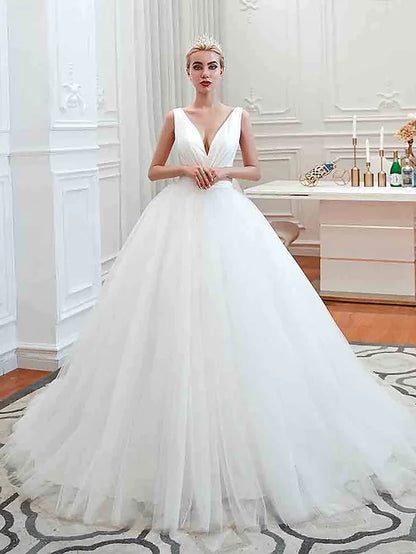 Model wearing a glamorous V-neck ball gown wedding dress with tulle skirt.