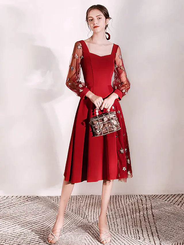 Woman wearing a glittering A-line cocktail dress with long sleeves and scoop neck.