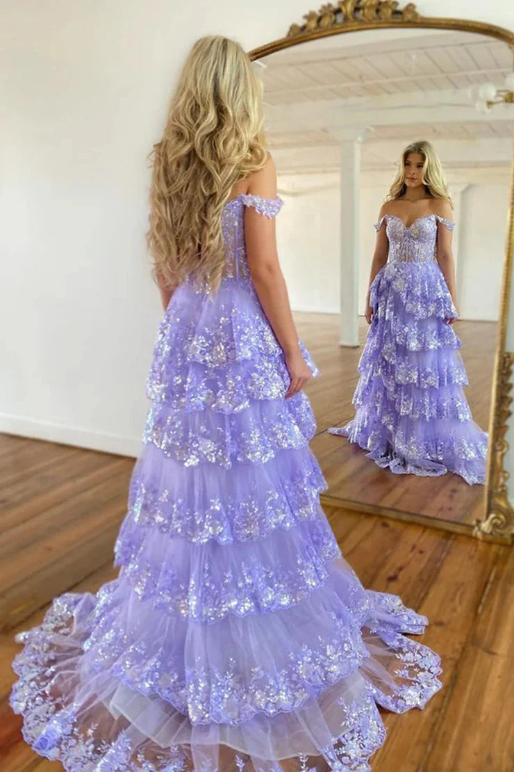 Side view of a model in a light blue off-shoulder tiered prom dress, showcasing the tiered skirt.