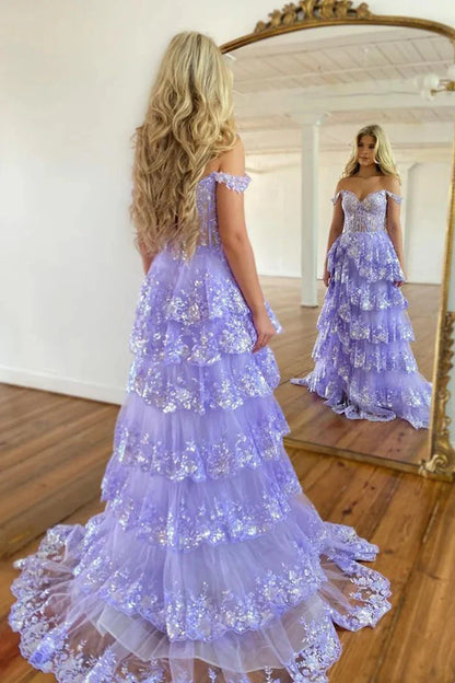 Side view of a model in a light blue off-shoulder tiered prom dress, showcasing the tiered skirt.