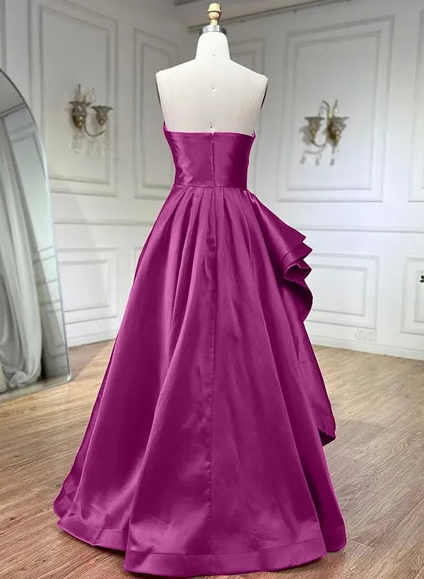 Side view of a model in a magenta A-line strapless pleated ruffled satin prom dress, showcasing the ruffled skirt.