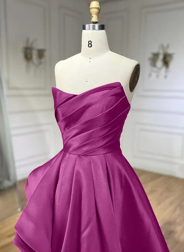 Back view of a model in a magenta A-line strapless pleated ruffled satin prom dress, highlighting the flowing skirt.