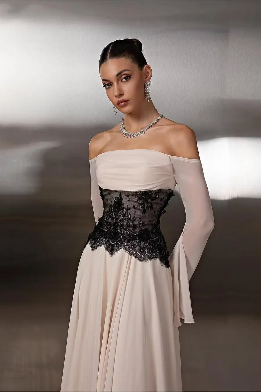 Back view of a nude A-line off-shoulder prom dress with black lace corset detail.
