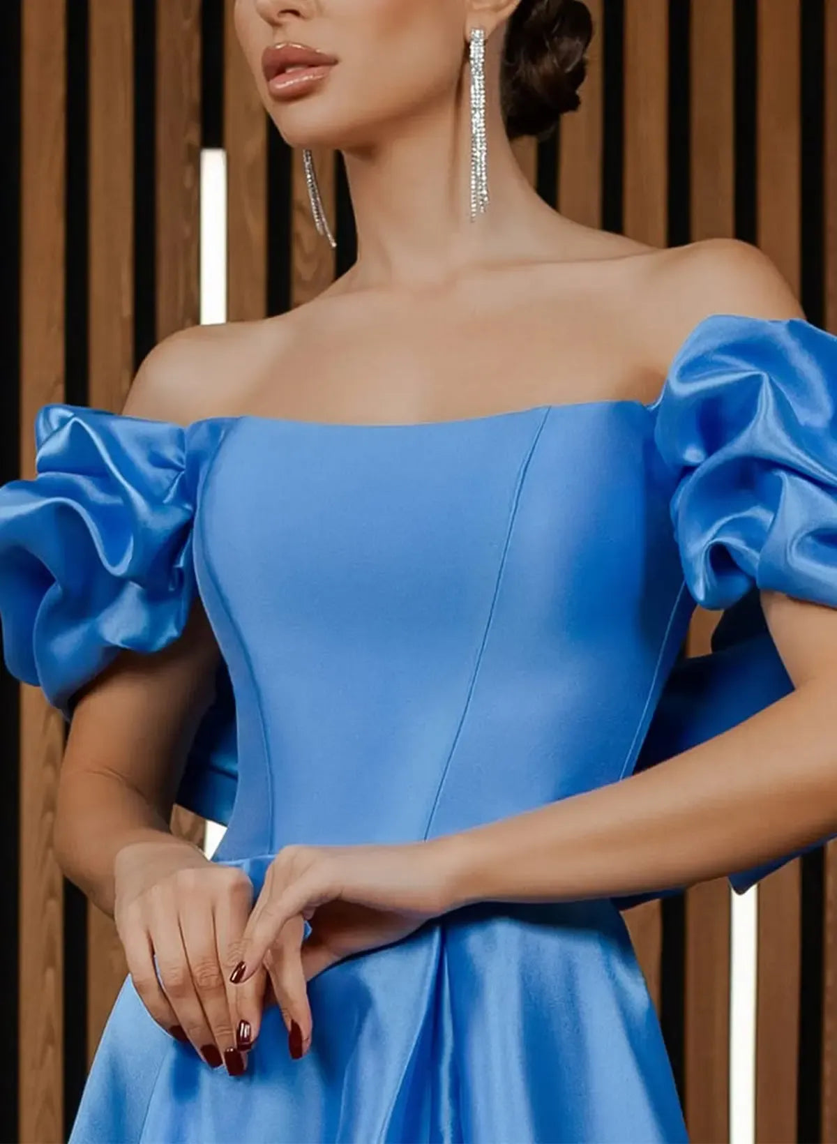 Close-up of the off-shoulder puff sleeves and satin fabric detail on an ocean blue prom dress.