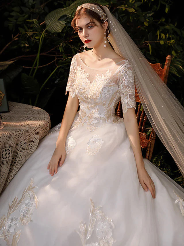Back view of a white princess ball gown wedding dress, showcasing the chapel train and delicate lace detailing.