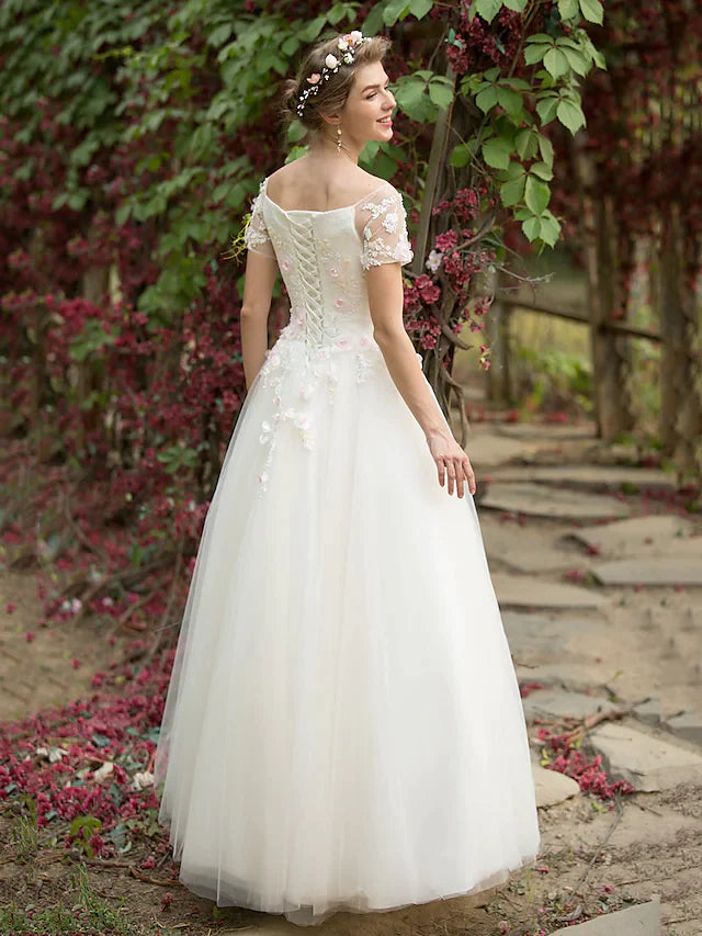 Close-up of the bateau neckline and beaded short sleeves on the wedding dress.
