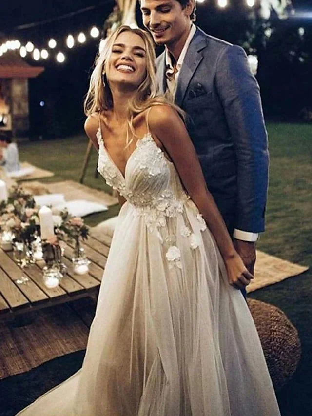 Elegant A-Line V-neck wedding dress with lace and tulle, featuring spaghetti straps and a flowing train.