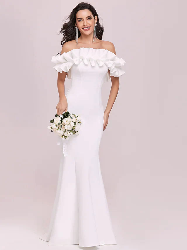 Model wearing a white off-shoulder wedding dress with spaghetti straps and ruffles.