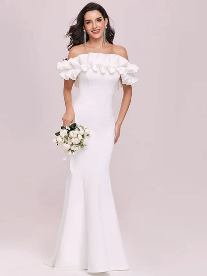 Model wearing a white off-shoulder wedding dress with spaghetti straps and ruffles.