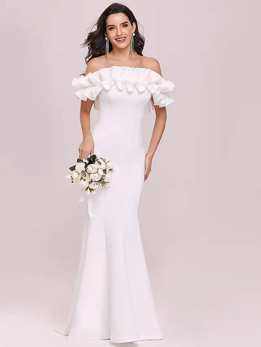 Model wearing a white off-shoulder wedding dress with spaghetti straps and ruffles.
