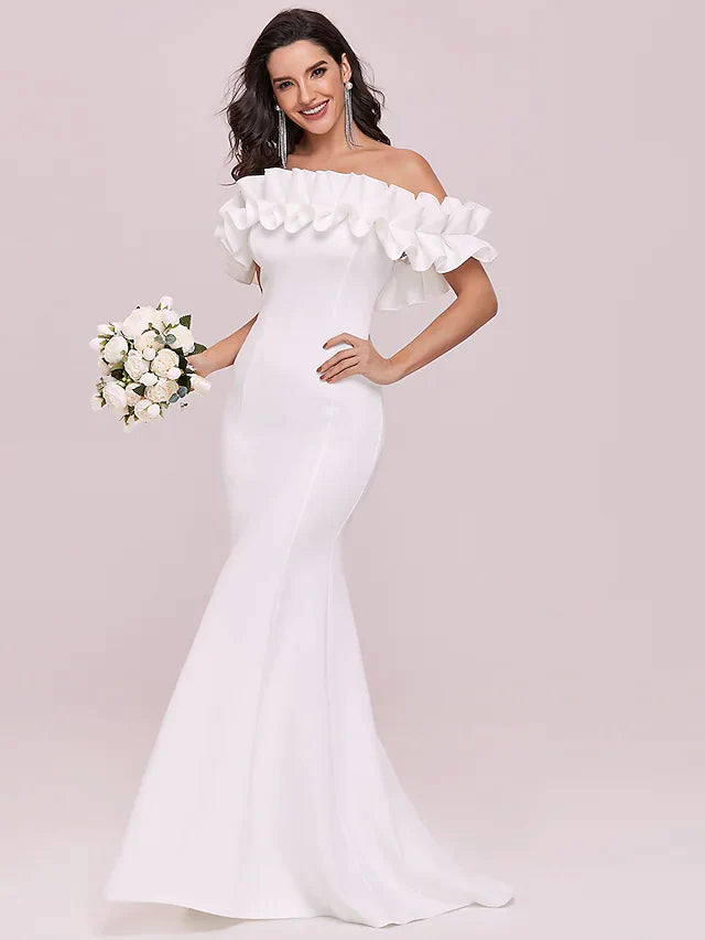 Full length view of a bride in a romantic off-shoulder wedding dress.