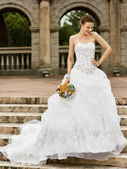 Romantic strapless ball gown wedding dress with a court train and pick-up skirt.