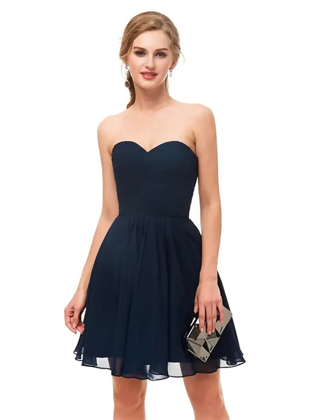 Model wearing a black A-line strapless knee-length cocktail dress.