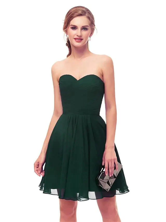 Model posing elegantly in a black strapless knee-length dress.