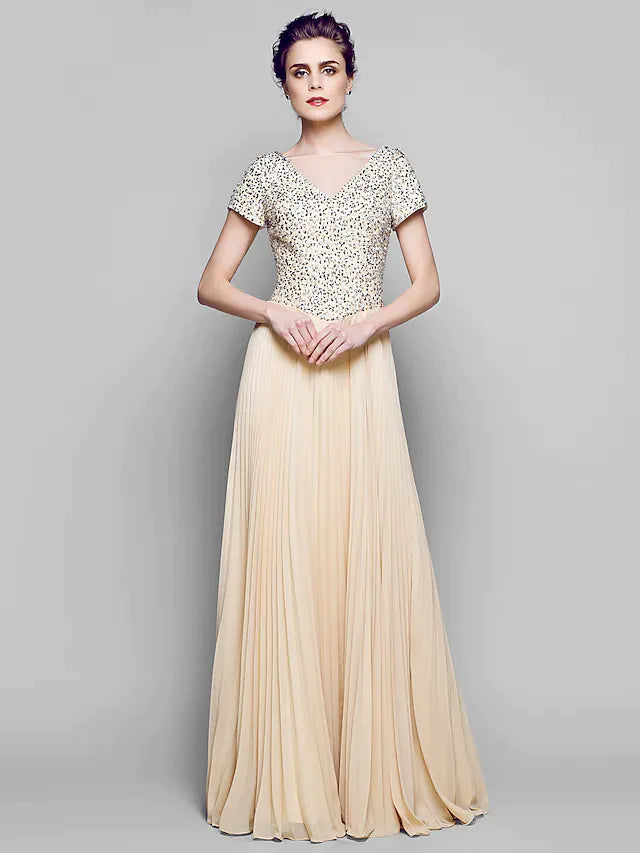 Woman wearing a sparkling A-Line Mother of the Bride gown with a bateau neck and short sleeves.