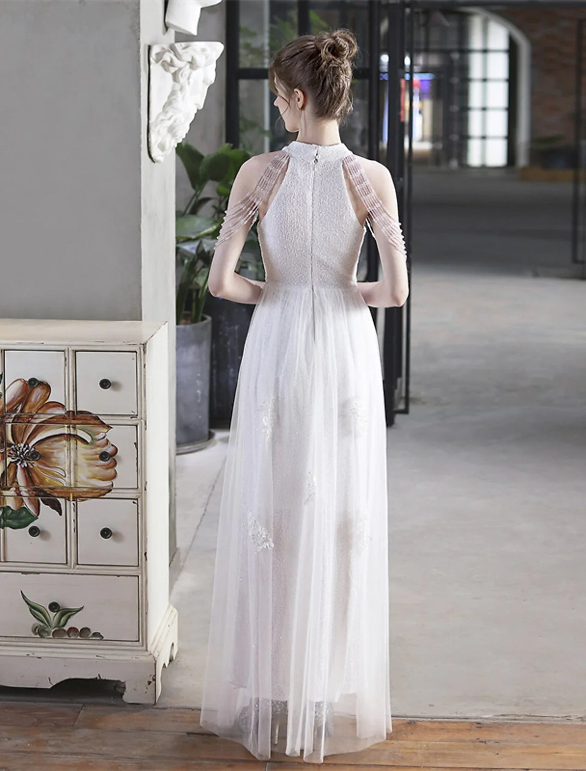 Close-up of sequin appliques on the high neck and short sleeve of the A-line dress.