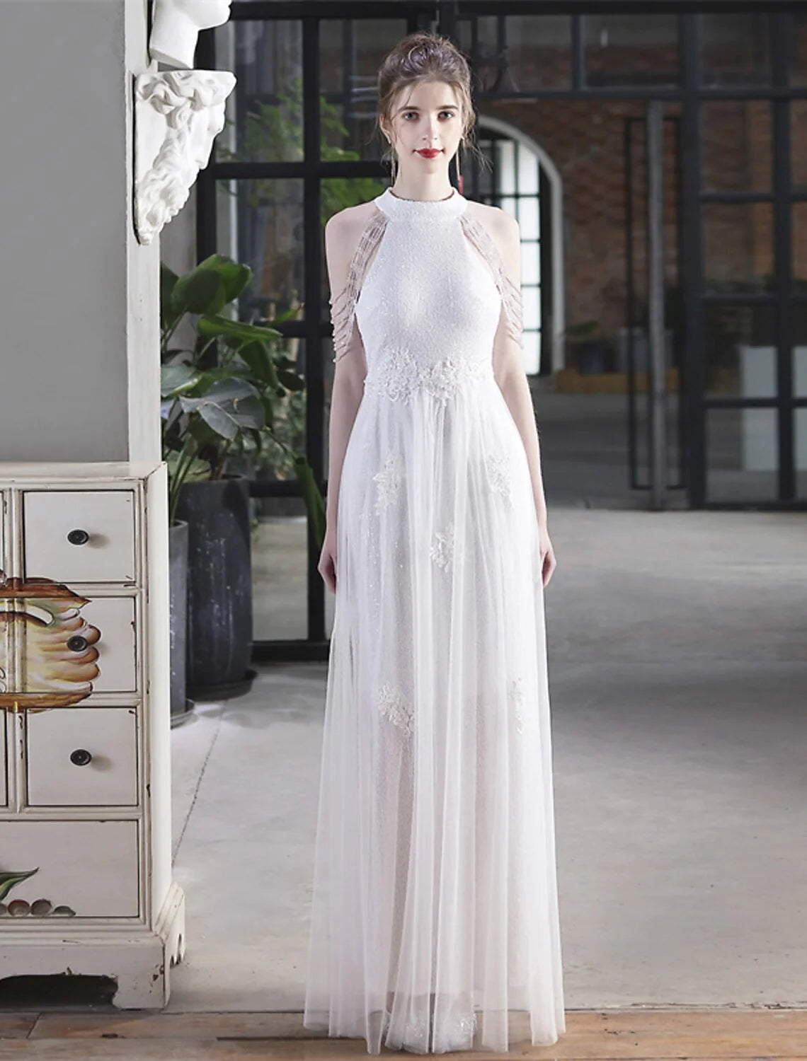 Back view of a model in a sparkling A-line floor-length prom dress.