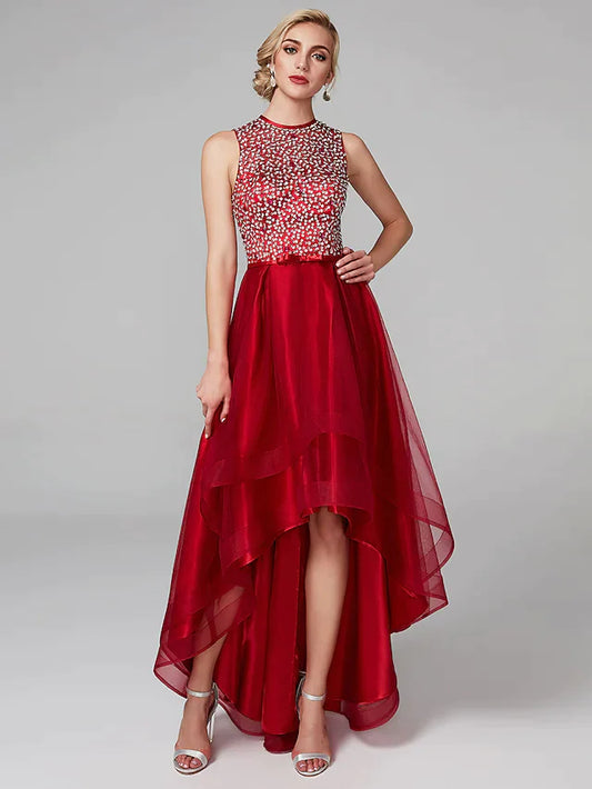 Woman wearing a sparkling A-line high-low cocktail dress with jewel neck and sequin details.