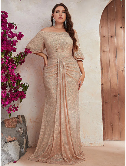 Woman wearing a sparkling A-line off-shoulder wedding guest dress with beading and a sweep train, front view.