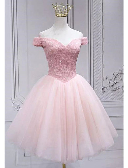 Model wearing a sparkling A-Line off-shoulder knee-length homecoming dress with sequins.
