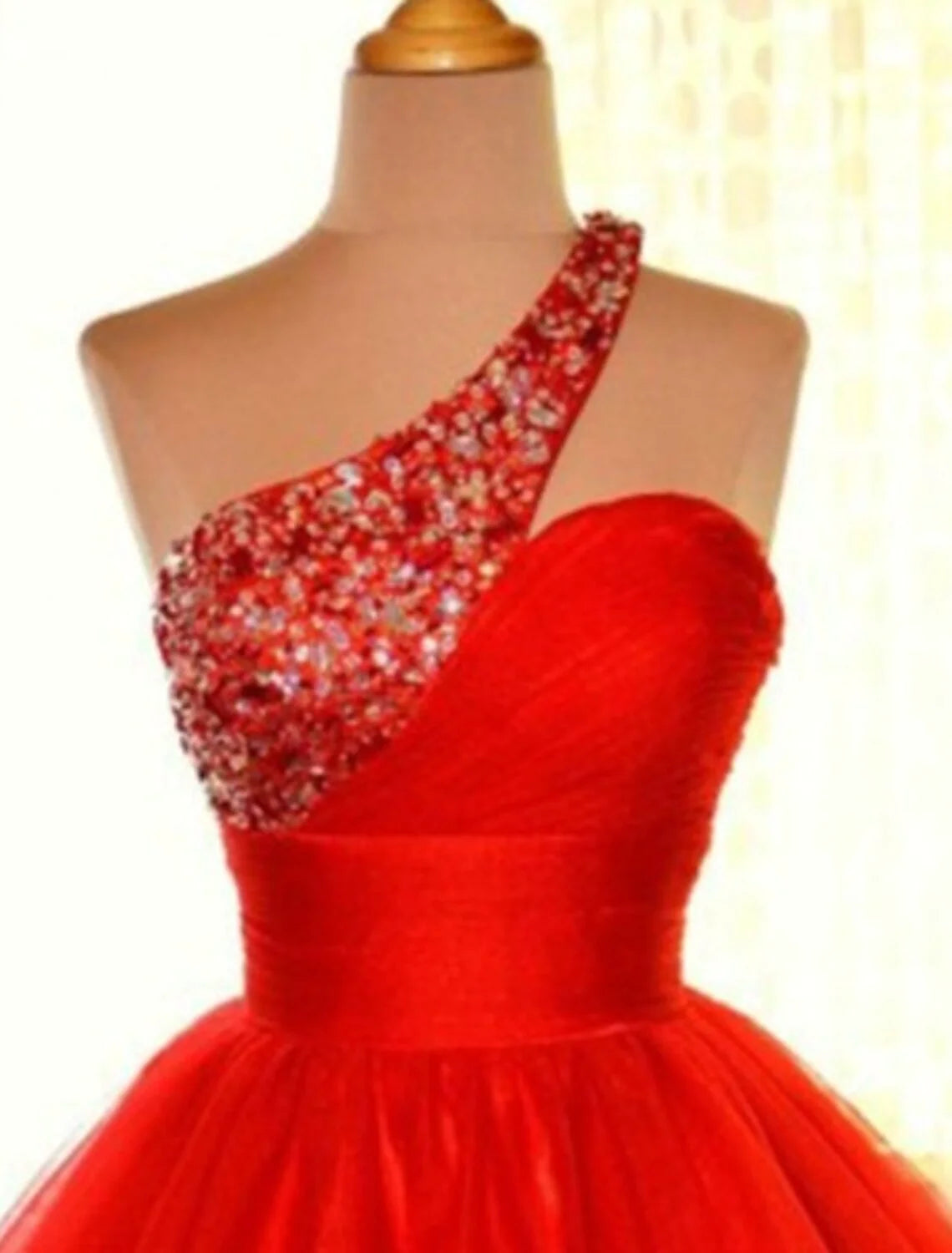 Model posing in a pink sequin tulle one-shoulder party dress.
