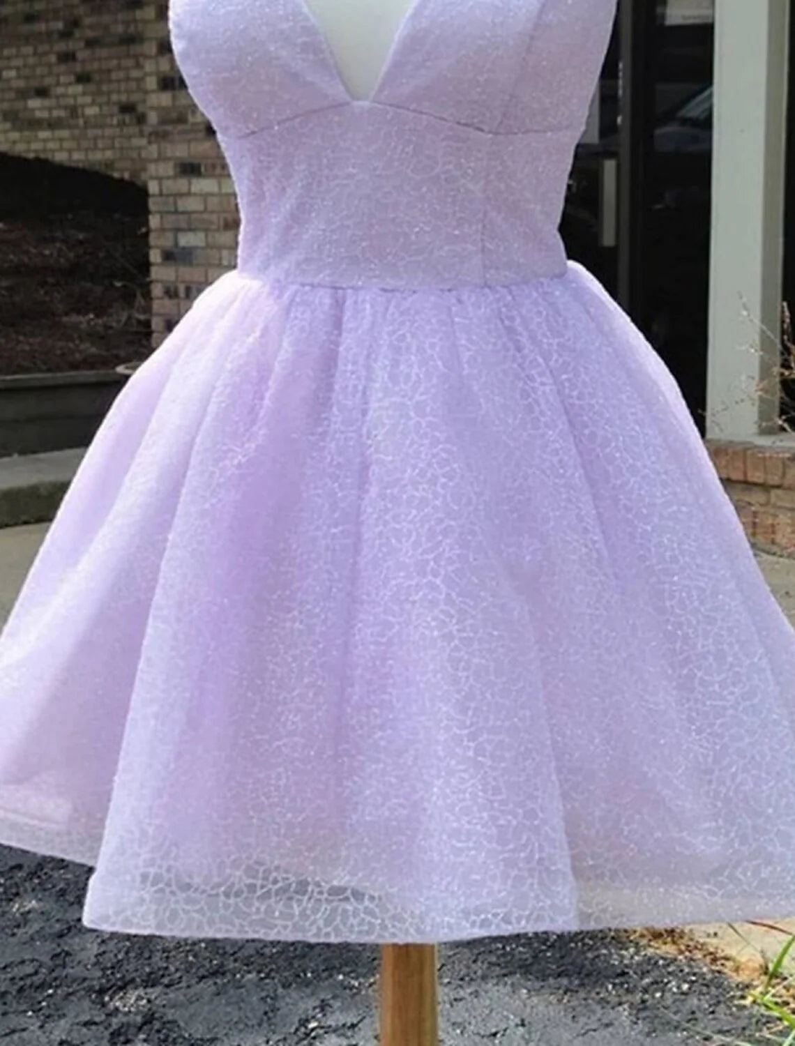 Back view of a woman in a shimmering A-line party dress with spaghetti straps.