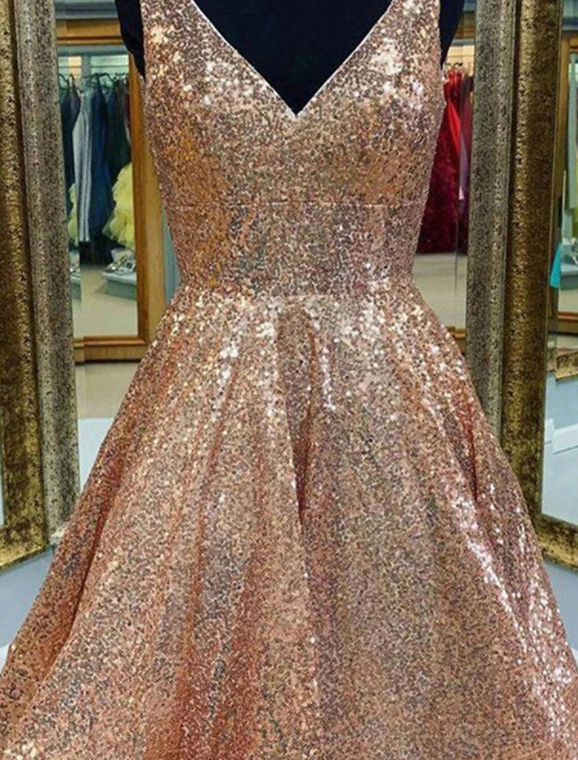 Woman in sparkling A-line V-neck tea length sequined homecoming dress, side view.