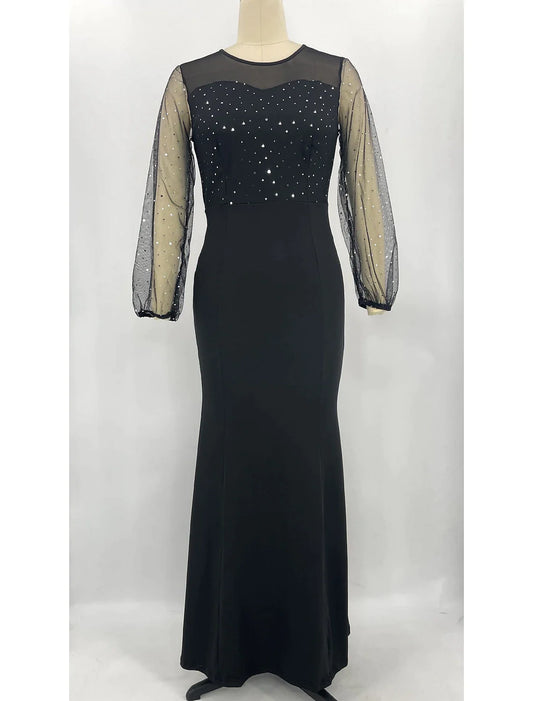 Woman wearing a sparkling long sleeve jewel neck mermaid trumpet formal dress with rhinestone crystals.