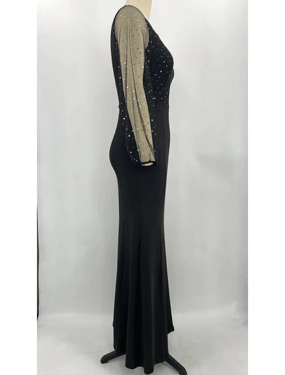Back view of a woman in a sparkling long sleeve jewel neck mermaid trumpet formal dress.
