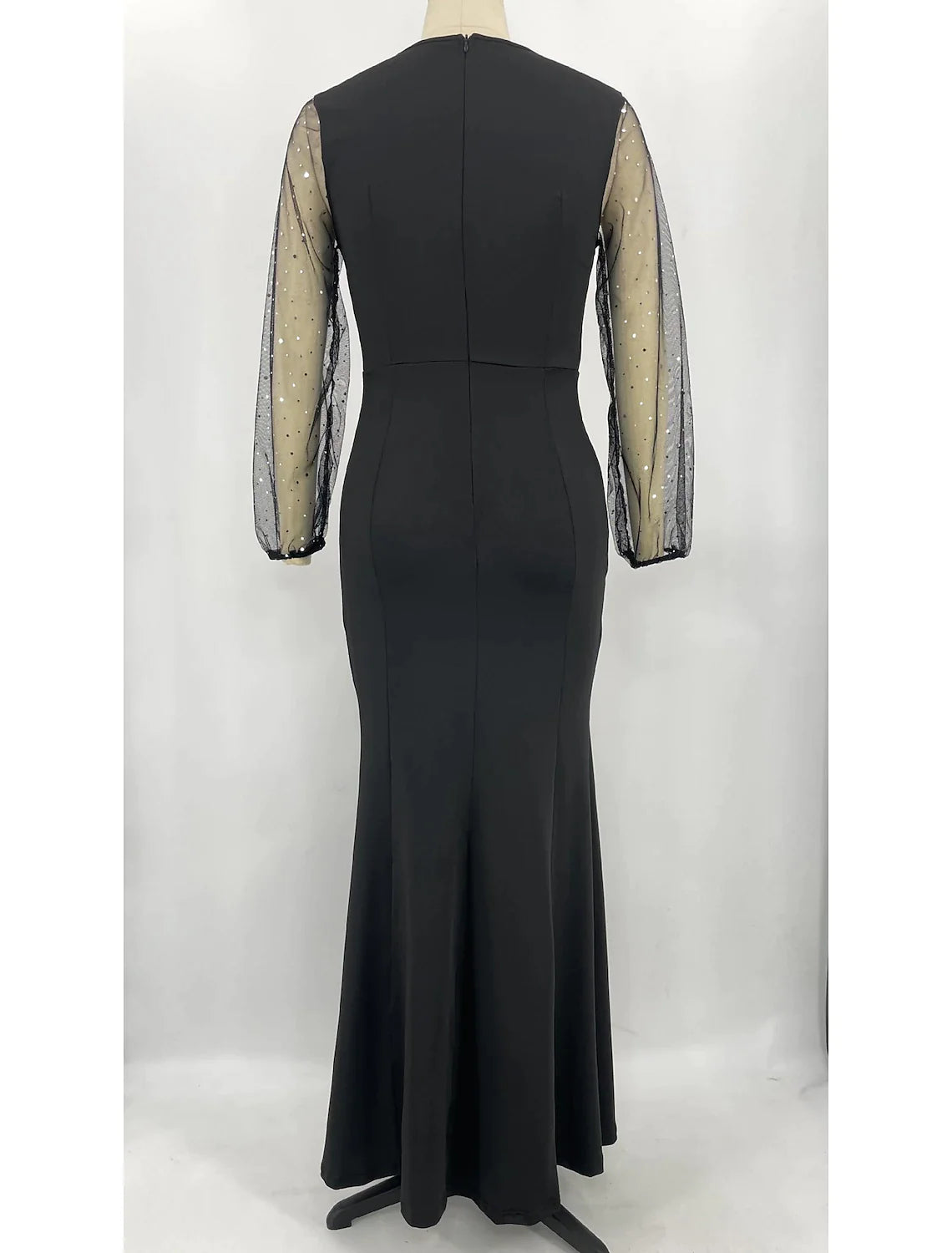 Side view of a woman in a sparkling long sleeve jewel neck mermaid trumpet formal dress.