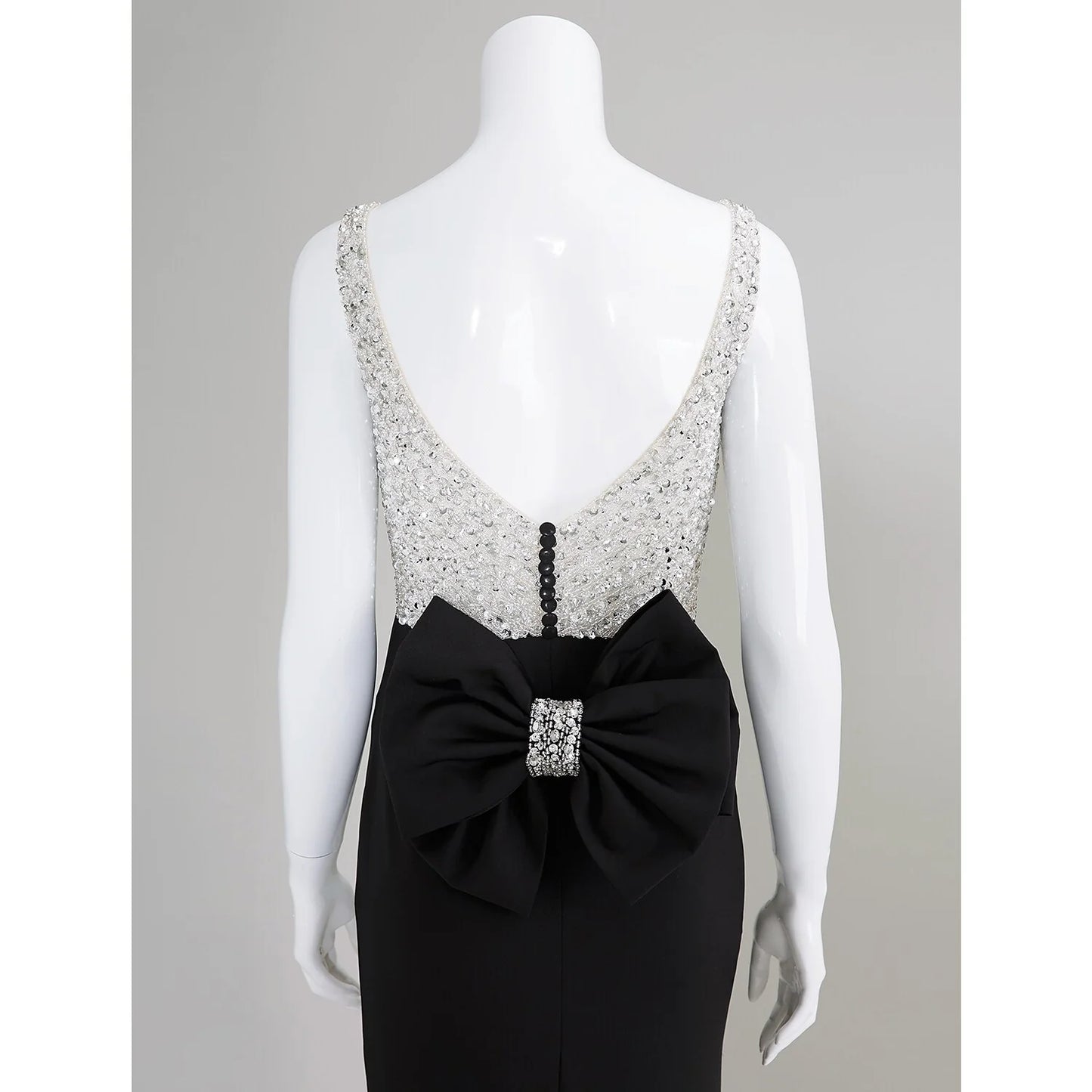 Detail of the elegant bows and beading embellishments on the dress.